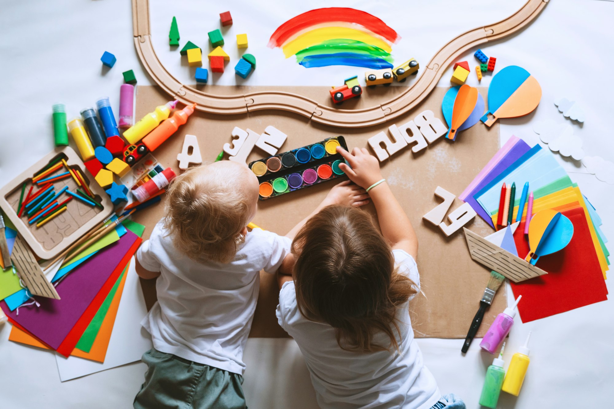 Children drawing and making crafts in kindergarten or daycare.